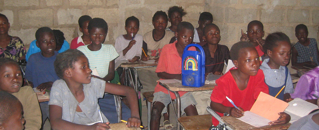 Students in Malawi listening to a radio
