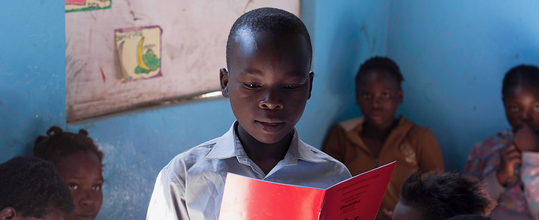 A child in Zambia works in his reading skills.