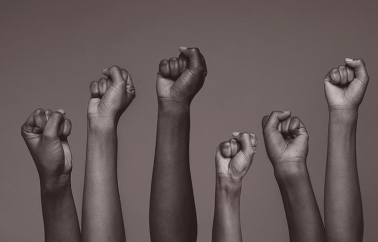 A photo of raised hands representing Lift Every Voice