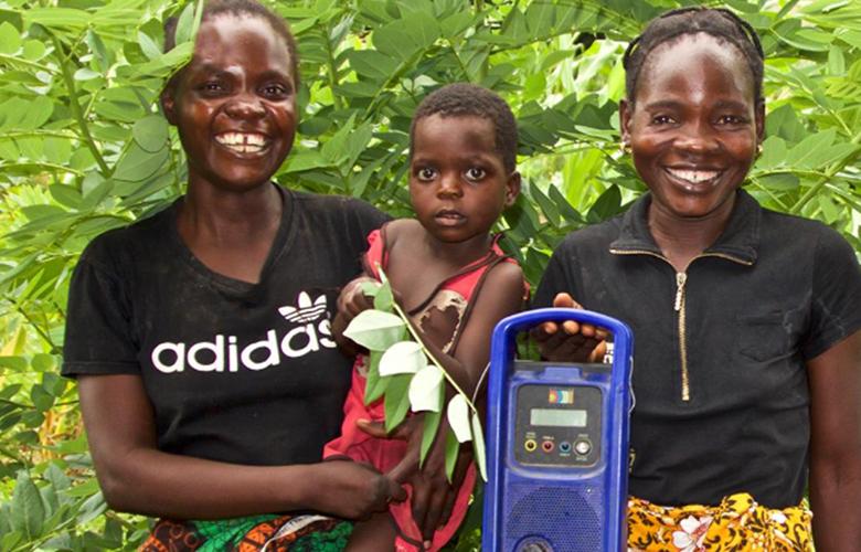 Remote Learning during COVID-19: EDC Interactive Audio Instruction Finds New Purpose A photo of parents and child with a radio