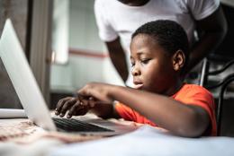 A photo of a child using a computer