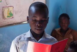 A child in Zambia works in his reading skills.