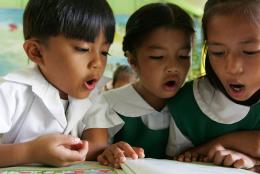 A photo of children reading representing To Improve Literacy, Examine the Book Supply Chain