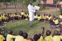 A teacher reads to students in Rwanda.