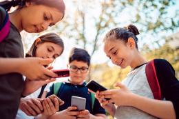 A photo of youth on phones representing Inclusion for Children with Special Needs Must Extend to Social Media