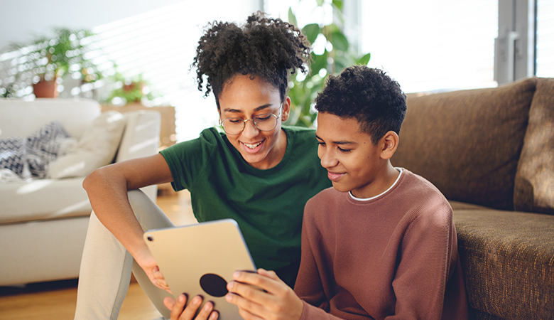 A photo of child and parent using a tablet.