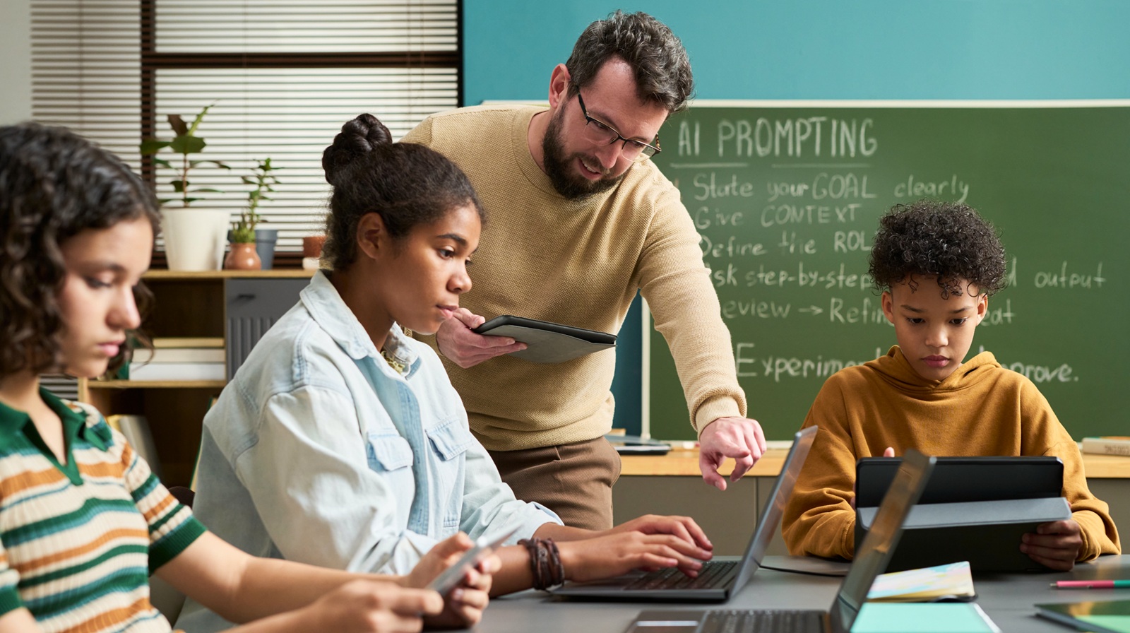 Photo of of an educator showing high school students how to write an AI prompt representing "EDC Launches New Work to Promote AI Fluency of Rural Students"
